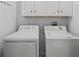Laundry room with a white washer and dryer, along with ample cabinet space at 1713 Trailwater St, Ruskin, FL 33570
