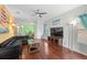 Open-concept living room with hardwood floors, modern ceiling fan and stylish decor at 1713 Trailwater St, Ruskin, FL 33570