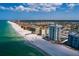Picturesque aerial view of a coastline featuring beachfront condos and a sandy beach at 17408 Gulf Blvd # 203, Redington Shores, FL 33708