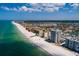 Scenic aerial view of beachfront condos, a sandy beach, and clear blue waters on a sunny day at 17408 Gulf Blvd # 203, Redington Shores, FL 33708