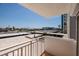 Expansive balcony view featuring a well maintained parking area and glimpses of the neighborhood, under a clear blue sky at 17408 Gulf Blvd # 203, Redington Shores, FL 33708