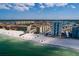 Aerial shot capturing the beautiful beachfront condos, sandy shore, and ocean view in a scenic coastal community at 17408 Gulf Blvd # 203, Redington Shores, FL 33708