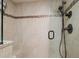 Close-up of the tiled shower featuring a glass door, a shower head and a convenient built-in seat at 17408 Gulf Blvd # 203, Redington Shores, FL 33708