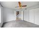 Bedroom featuring plush carpet, a ceiling fan, double closets, and an open doorway to a stairway at 1815 Cypress Trace Dr, Safety Harbor, FL 34695