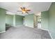 Large bedroom with soft carpet flooring, ceiling fan, and a mirrored door entrance to the en-suite bathroom at 1815 Cypress Trace Dr, Safety Harbor, FL 34695