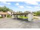Modern covered carport parking with white support beams and lush green surroundings at 1815 Cypress Trace Dr, Safety Harbor, FL 34695