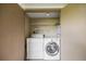 A laundry room with a washer, dryer, and wire shelving, offering convenience and functionality at 1815 Cypress Trace Dr, Safety Harbor, FL 34695