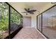 An enclosed patio featuring a ceiling fan and a decorative tiled floor at 1815 Cypress Trace Dr, Safety Harbor, FL 34695