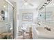 Bright bathroom featuring a glass enclosed shower, vanity with double sinks, and coastal decor at 18675 Us Highway 19 N # 261, Clearwater, FL 33764