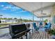 Waterfront patio with blue seating, grill, ceiling fan, and colorful lights perfect for entertaining guests at 18675 Us Highway 19 N # 261, Clearwater, FL 33764