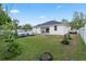 Large backyard with cars parked on a well-manicured lawn, showcasing a single-story home with a dark roof at 19212 Sunlake Blvd, Lutz, FL 33558