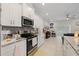 Well-appointed kitchen with stainless steel appliances, white cabinetry and adjacent living space at 19212 Sunlake Blvd, Lutz, FL 33558