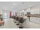 Bright open-concept kitchen with island seating, white cabinets, stainless appliances and tile floors at 19212 Sunlake Blvd, Lutz, FL 33558
