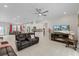 Open-concept living space featuring tile flooring, a ceiling fan and a seamless flow to the adjacent kitchen at 19212 Sunlake Blvd, Lutz, FL 33558