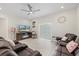 Bright living room features a ceiling fan, tile floors, and comfortable brown leather seating at 19212 Sunlake Blvd, Lutz, FL 33558