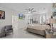 Spacious main bedroom with light tile floors, a ceiling fan, a mounted TV, and an adjoining bathroom at 19212 Sunlake Blvd, Lutz, FL 33558