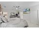 This well-lit main bedroom boasts a mounted TV, a ceiling fan, and an en suite bathroom at 19212 Sunlake Blvd, Lutz, FL 33558