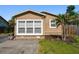 Close-up view of a home showcasing large windows, landscaping and a paved driveway at 2018 21St S St, St Petersburg, FL 33712