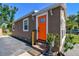 Inviting home entrance featuring an orange door, potted plants, and exterior lighting at 2018 21St S St, St Petersburg, FL 33712