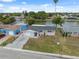 Aerial view of a single-story home with an attached garage and water views at 2252 Society Dr, Holiday, FL 34691
