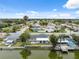 Waterfront home with a backyard featuring a white picket fence, dock, and screened-in pool area for outdoor enjoyment at 2252 Society Dr, Holiday, FL 34691