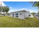 This fenced backyard features a large lawn and sliding glass doors at 2252 Society Dr, Holiday, FL 34691