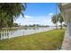 This home features a backyard with a white picket fence and water views at 2252 Society Dr, Holiday, FL 34691