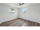 Bedroom features wood floors, ceiling fan, and natural light at 2252 Society Dr, Holiday, FL 34691