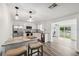 Modern kitchen with white cabinets, stainless steel appliances, breakfast bar, and an open view to the dining area at 2252 Society Dr, Holiday, FL 34691