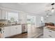 Modern kitchen features white cabinets, stainless appliances, and views into the dining room at 2252 Society Dr, Holiday, FL 34691