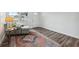 Bright living room features wood-look floors, neutral walls, a cozy chair, and a vintage rug with front yard view at 2252 Society Dr, Holiday, FL 34691