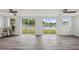 Bright living room features ceiling fans, wood floors, and sliding glass doors with water view at 2252 Society Dr, Holiday, FL 34691