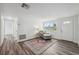 Bright living room featuring wood-look floors, neutral walls, a cozy chair, and a vintage rug with a front door view at 2252 Society Dr, Holiday, FL 34691