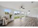 Bright living room features ceiling fans, wood floors, and sliding glass doors with water view at 2252 Society Dr, Holiday, FL 34691