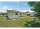 Backyard view showing a grassy area, a small building and a partial view of neighboring houses at 2626 Cheryle Ln, Sarasota, FL 34237