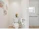 Bright white bathroom featuring decorative wall art, toilet with adjacent shower and grab bars at 2626 Cheryle Ln, Sarasota, FL 34237