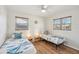 This cozy bedroom has two beds, light wood floors, a ceiling fan, and windows with bright natural light at 2626 Cheryle Ln, Sarasota, FL 34237