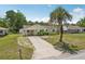 Aerial front exterior showcasing the well-maintained lawn, driveway, and mature palm tree at 2626 Cheryle Ln, Sarasota, FL 34237