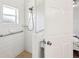 Walk-in shower featuring white tile, safety bar and shower caddy at 2626 Cheryle Ln, Sarasota, FL 34237