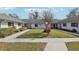 Manicured front lawn with a landscaped walkway leading to the entrance of the home at 2725 Countryside Blvd # 103, Clearwater, FL 33761