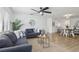 Bright living room features a ceiling fan, gray couches, and view to dining area at 2725 Countryside Blvd # 103, Clearwater, FL 33761