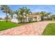 Beautiful single Gathering home with mature palms, green grass, and brick paver driveway at 281 44Th Ave, St Pete Beach, FL 33706