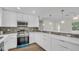 Modern kitchen featuring white cabinets, stainless steel appliances, and stylish backsplash at 281 44Th Ave, St Pete Beach, FL 33706