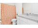 Bright bathroom featuring a single vanity with white cabinets and a shower with a peach-colored curtain at 2906 Boxwood Grove Row, Wesley Chapel, FL 33543
