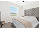 Bright bedroom with a stylish headboard, plush bedding, and a sunny window with natural light at 2906 Boxwood Grove Row, Wesley Chapel, FL 33543