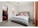 Spacious bedroom featuring a tufted headboard, ensuite bathroom, and a walk-in closet with open door at 2906 Boxwood Grove Row, Wesley Chapel, FL 33543
