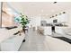 Bright, open-concept living space flows into the modern kitchen with tile flooring and neutral color scheme at 2906 Boxwood Grove Row, Wesley Chapel, FL 33543