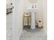 Compact powder room with a sleek pedestal sink, stylish faucet, and modern decorative accents at 2906 Boxwood Grove Row, Wesley Chapel, FL 33543