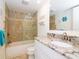 Updated bathroom features a granite vanity, soaking tub with shower, and tiled walls at 29147 Bay Hollow Dr # 3217, Wesley Chapel, FL 33543