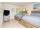 Well-lit bedroom with two beds and tiled flooring and a TV sitting on a dresser at 29147 Bay Hollow Dr # 3217, Wesley Chapel, FL 33543
